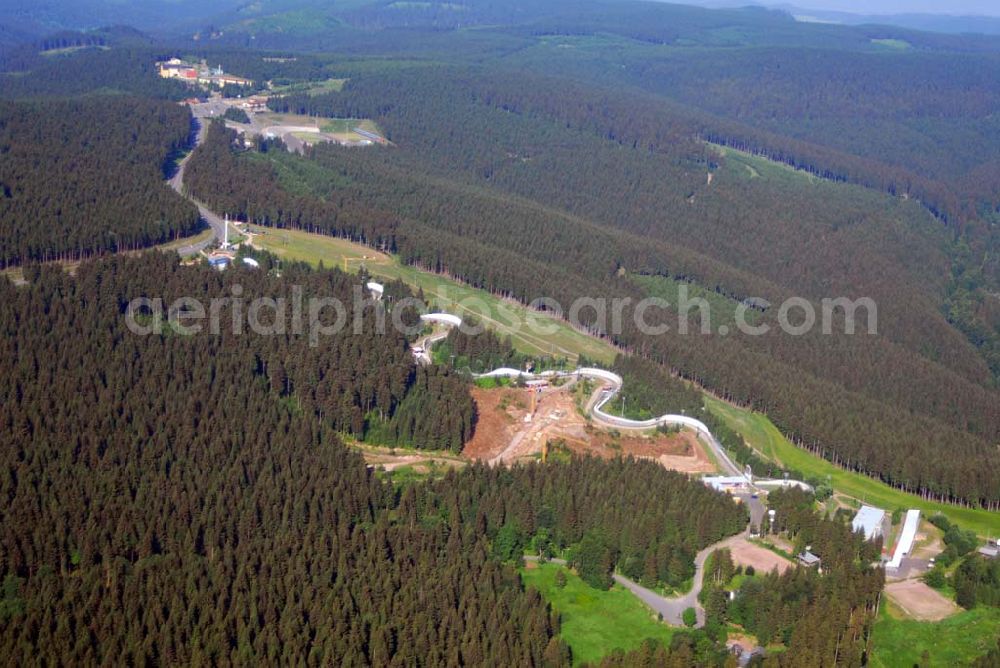 Oberhof from the bird's eye view: Blick auf die Bob- und Rodelbahn BSR Rennsteig Oberhof e.V. in der Gräfenrodaer Straße 2 in 98559 Oberhof. Fon: 036842) 212 02 Mail: mail@bsr-oberhof.de. Ziel des ca. 280 Mitglieder starken Vereins ist es, den Kufensport in den Disziplinen Bob, Skeleton und Renn- rodeln intensiv zu fördern. Gleichzeitig ist der BSR professioneller Ausrichter vieler internationaler Wettkämpfe in der berühmten Oberhofer Kunsteis- schlange. Seit 1973 werden hier so hochkarätige Wettbewerbe, Weltmeisterschaften (1973 und 1985), Europameister- schaften (1979 und 1998), jährliche Weltcups sowie unzählige nationale Sportveranstaltungen, ausgetragen.