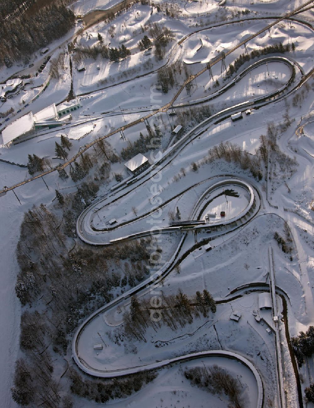 Winterberg from the bird's eye view: Blick auf die winterlich verschneite Bobbahn Winterberg. Die 1609 m lange Kunsteisbahn wird für den Rodel-, Skeleton- und Bob-Sport genutzt. View of the winterly snowy bobsleigh run Winterberg. The 1609 m long ice track is used for the luge, skeleton and bobsled sport.