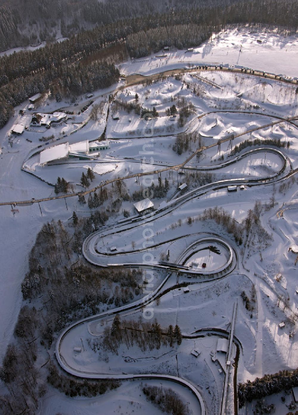 Aerial image Winterberg - Blick auf die winterlich verschneite Bobbahn Winterberg. Die 1609 m lange Kunsteisbahn wird für den Rodel-, Skeleton- und Bob-Sport genutzt. View of the winterly snowy bobsleigh run Winterberg. The 1609 m long ice track is used for the luge, skeleton and bobsled sport.