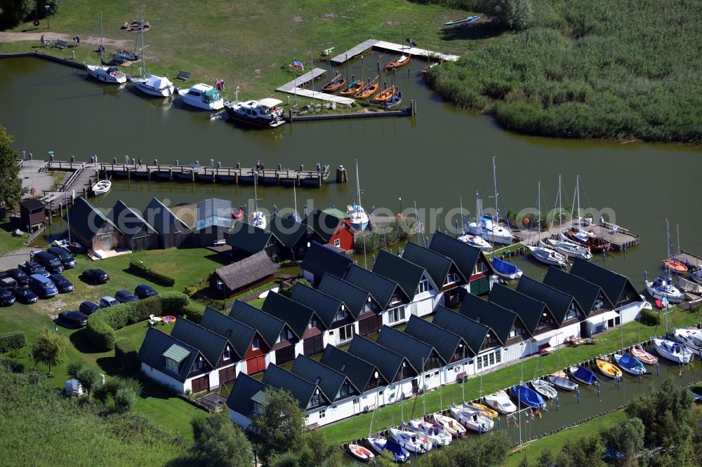 Ahrenshoop from the bird's eye view: Boat House ranks with the recreational marine jetties and boat mooring area on the banks of see Saaler Bodden in Ahrenshoop in the state Mecklenburg - Western Pomerania