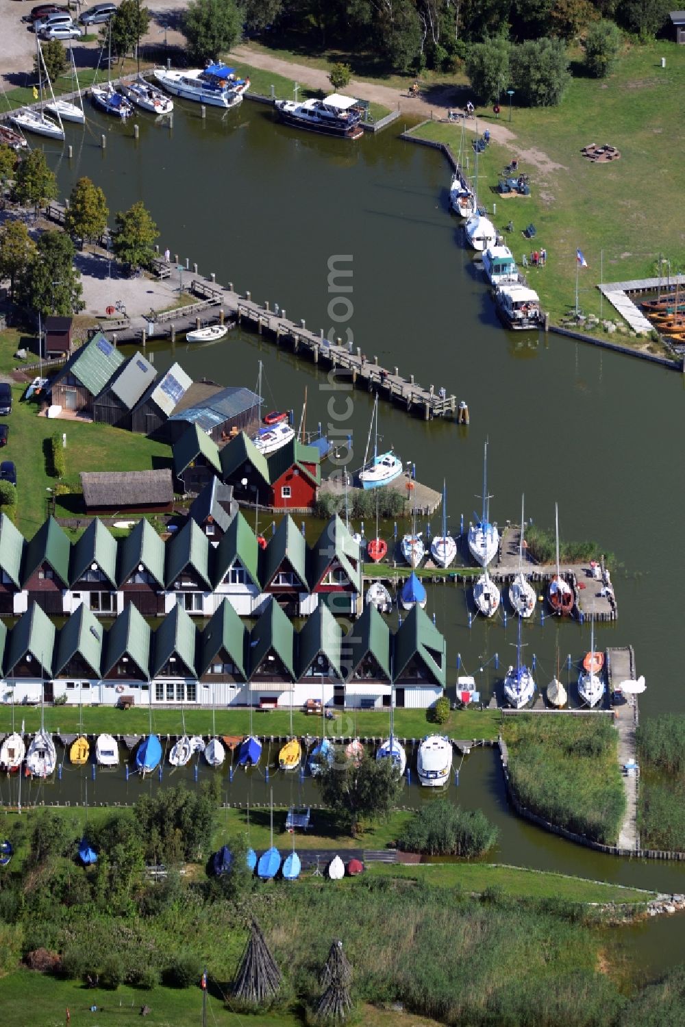 Ahrenshoop from the bird's eye view: Boat House ranks with the recreational marine jetties and boat mooring area on the banks of see Saaler Bodden in Ahrenshoop in the state Mecklenburg - Western Pomerania