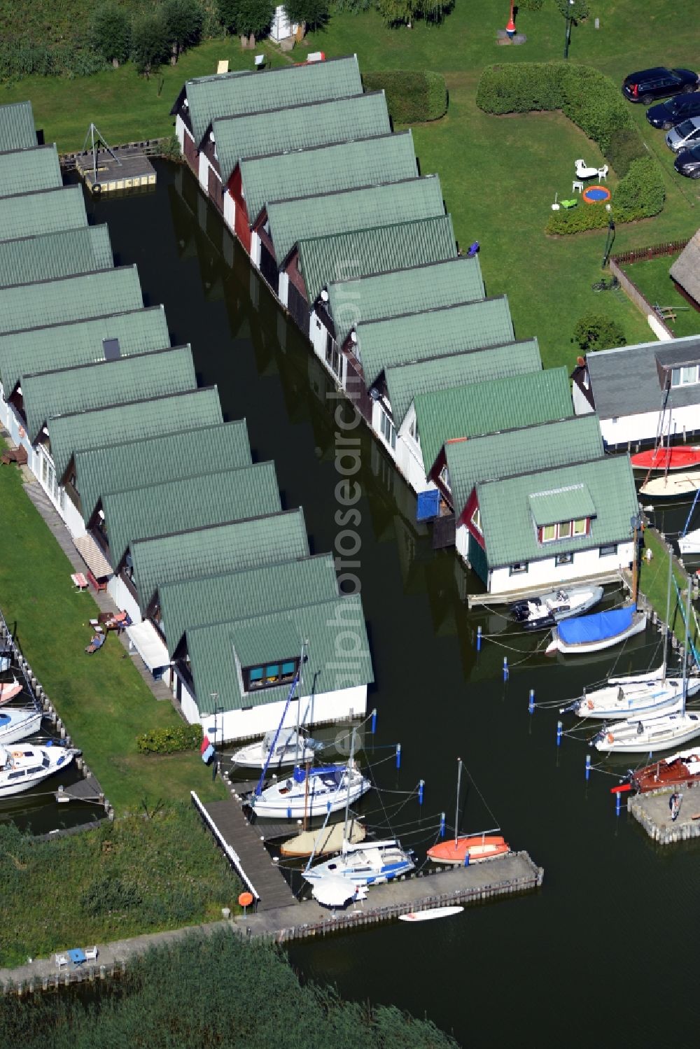 Ahrenshoop from the bird's eye view: Boat House ranks with the recreational marine jetties and boat mooring area on the banks of see Saaler Bodden in Ahrenshoop in the state Mecklenburg - Western Pomerania