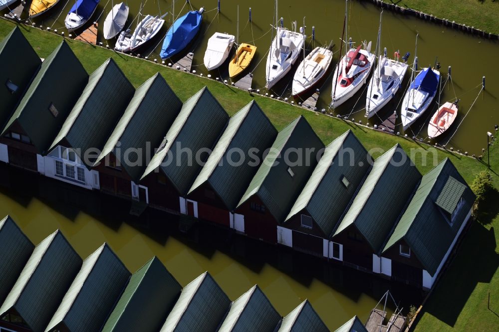 Ahrenshoop from the bird's eye view: Boat House ranks with the recreational marine jetties and boat mooring area on the banks of see Saaler Bodden in Ahrenshoop in the state Mecklenburg - Western Pomerania