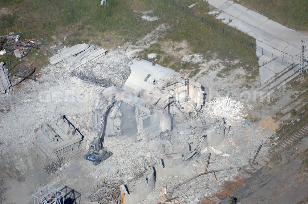 ESPENHAIN from above - Espenhain: Teile eines gesprengten Schornsteins zerkleinert ein Bagger der Mitteldeutschen Braunkohle-Strukturförderungsgesellschaft (MBS) auf dem Gelände des im März 1995 stillgelegten Braunkohlekraftwerkes I in Espenhain bei Leipzig. Das Kraftwerk hatte zusammen mit dem im Juni 1996 abgeschalteten Werk II zuletzt 1,36 Milliarden Kilowattstunden Elektroenergie in das öffentliche Stromnetz eingespeist. Der Abriß und die Sanierung des Geländes, einschließlich Brikettfabrik und Schwelerei soll bis zur Jahrtausendwende abgeschlossen sein. Mitteldeutsche Industriepark Espenhain