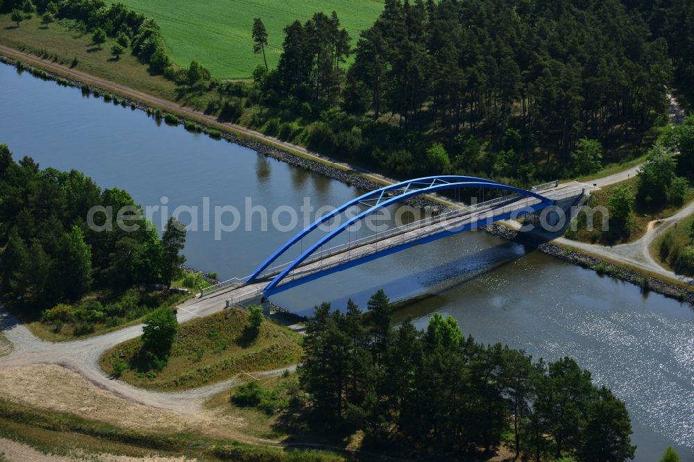 Aerial photograph Burg (bei Magdeburg) - Bridge over the Elbe-Havel-Kanal in the West of the town of Burg (bei Magdeburg) in the state of Saxony-Anhalt. The distinct blue arc bridge spans the canal in the West of the town. The bridge is surrounded by forest and is one of several bridges on the canal