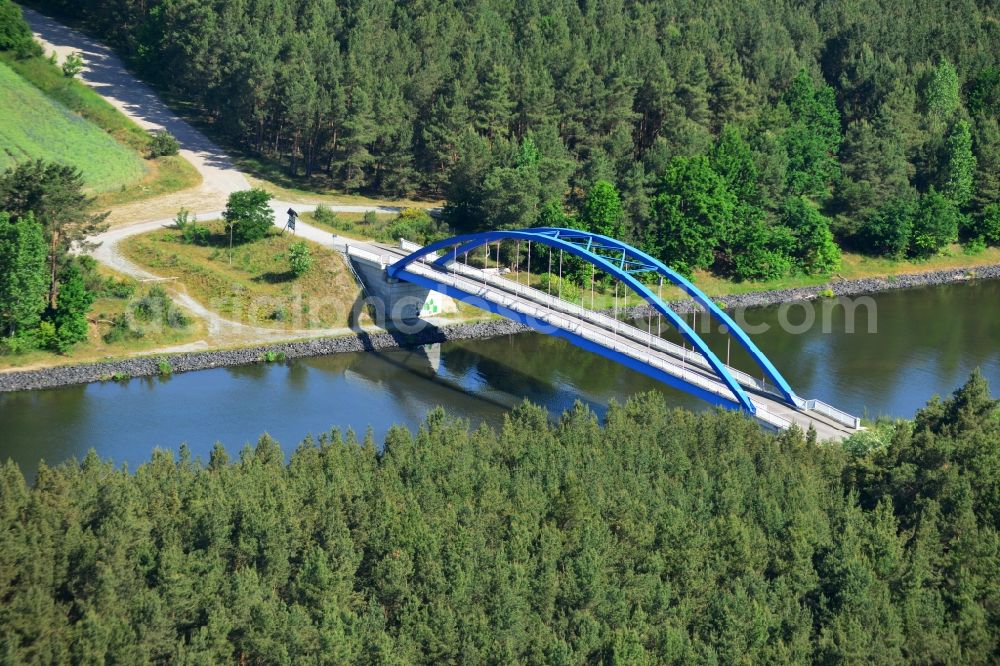 Aerial photograph Burg (bei Magdeburg) - Bridge over the Elbe-Havel-Kanal in the West of the town of Burg (bei Magdeburg) in the state of Saxony-Anhalt. The distinct blue arc bridge spans the canal in the West of the town. The bridge is surrounded by forest and is one of several bridges on the canal