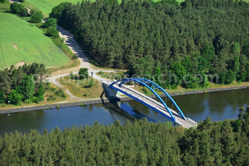 Burg (bei Magdeburg) from above - Bridge over the Elbe-Havel-Kanal in the West of the town of Burg (bei Magdeburg) in the state of Saxony-Anhalt. The distinct blue arc bridge spans the canal in the West of the town. The bridge is surrounded by forest and is one of several bridges on the canal