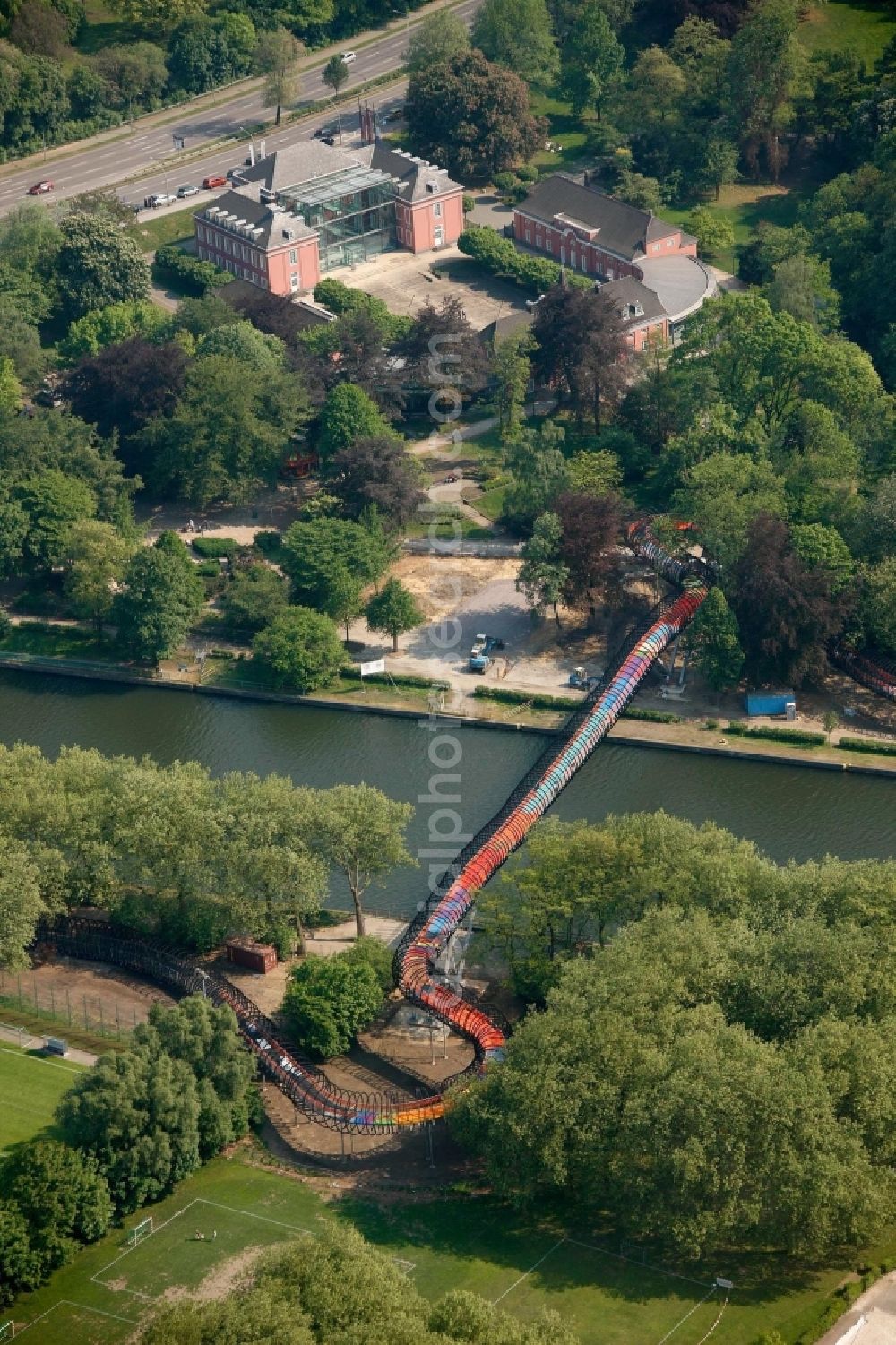 Aerial photograph Oberhausen - View of the bridge Slinky Springs to Fame in Oberhausen in North Rhine-Westphalia. The bridge sculpture with spiral over the Rhine-Herne-Kanal was conceived within the framework of the art project Emscherkunst.2010 by the sculptor Tobias Rehberger in collaboration with the engineering firm Schlaich, Bergemann and Partner and opened in 2011. The pedestrian and bicycle bridge connects the garden of the castle with the Emscherinsel