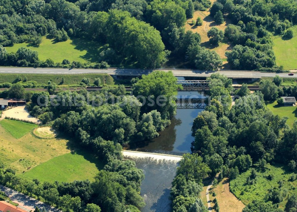 Aerial image Saalfeld/Saale - The federal highway B85 crosses in the northern part of Saalfeld / Saale in Thuringia the river Saale. The train tracks run on a separate bridge. A weir accumulates at this point the river Saale