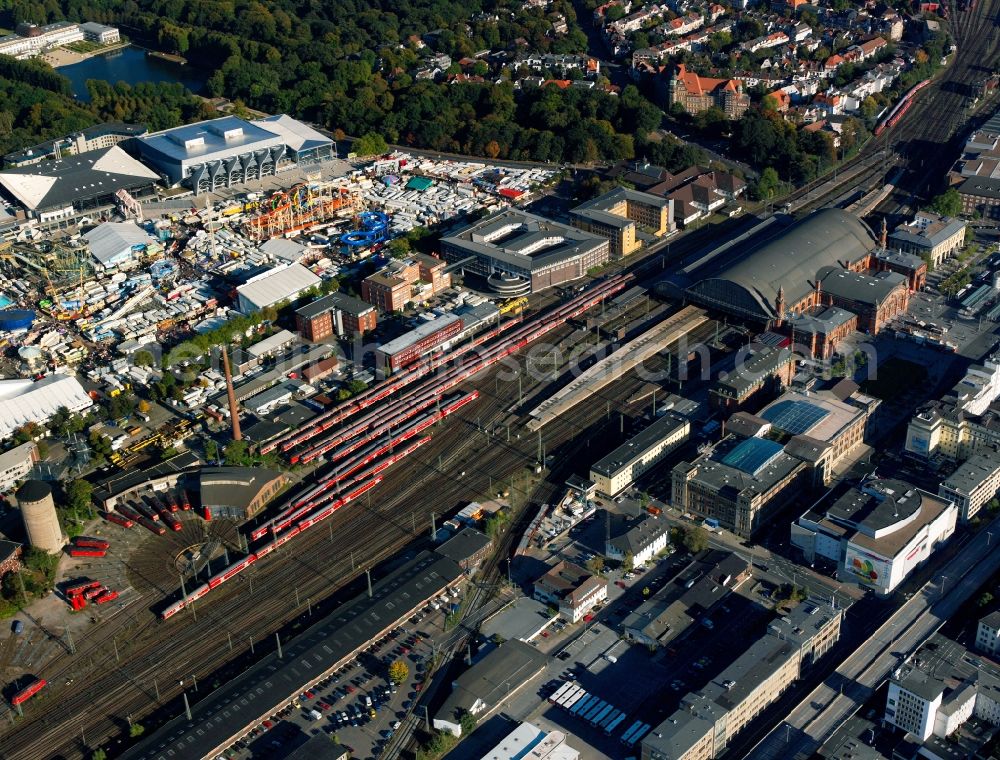 Bremen from above - Bremen Main Station and fair in front of the OEVB Arena in Bremen in the state of Bremen. The historic main building of the station was designed by Hubert Stier in a Neo-Renaissance style and built between 1885 and 1889. Behind it, the railways, railway tracks and garages are located. On the Buergerweide square - the square in front of the exhibition centre OEVB Arena - a fun fair with different attractions takes place