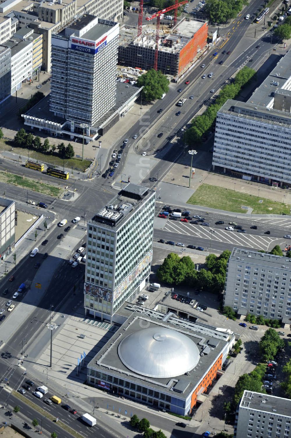 Berlin from above - Blick auf das Bürogebäude - Hochhaus Haus des Lehrers mit der Kongresshalle des Berliner Congress Center (bcc) am Alexanderplatz in Mitte. Die Besonderheit des Gebäudes ist ein umlaufender Fries zwischen dem zweiten und fünften Obergeschoss, im Volksmund „Bauchbinde“ genannt. Dieser von Walter Womacka in Anlehnung an mexikanische Wandbilder entworfene Fries mit dem Namen Unser Leben zeigt Darstellungen aus dem gesellschaftlichen Leben in der DDR. Mit sieben Metern Höhe und 125 Metern Länge zählt es zu den größten Kunstwerken Europas. Der gesamte Gebäudekomplex der WBM Wohnungsbaugesellschaft Berlin-Mitte mbH steht unter Denkmalschutz. Office building - building the teacher's house with the Congress Hall of the Berliner Congress Center in Berlin - Mitte.