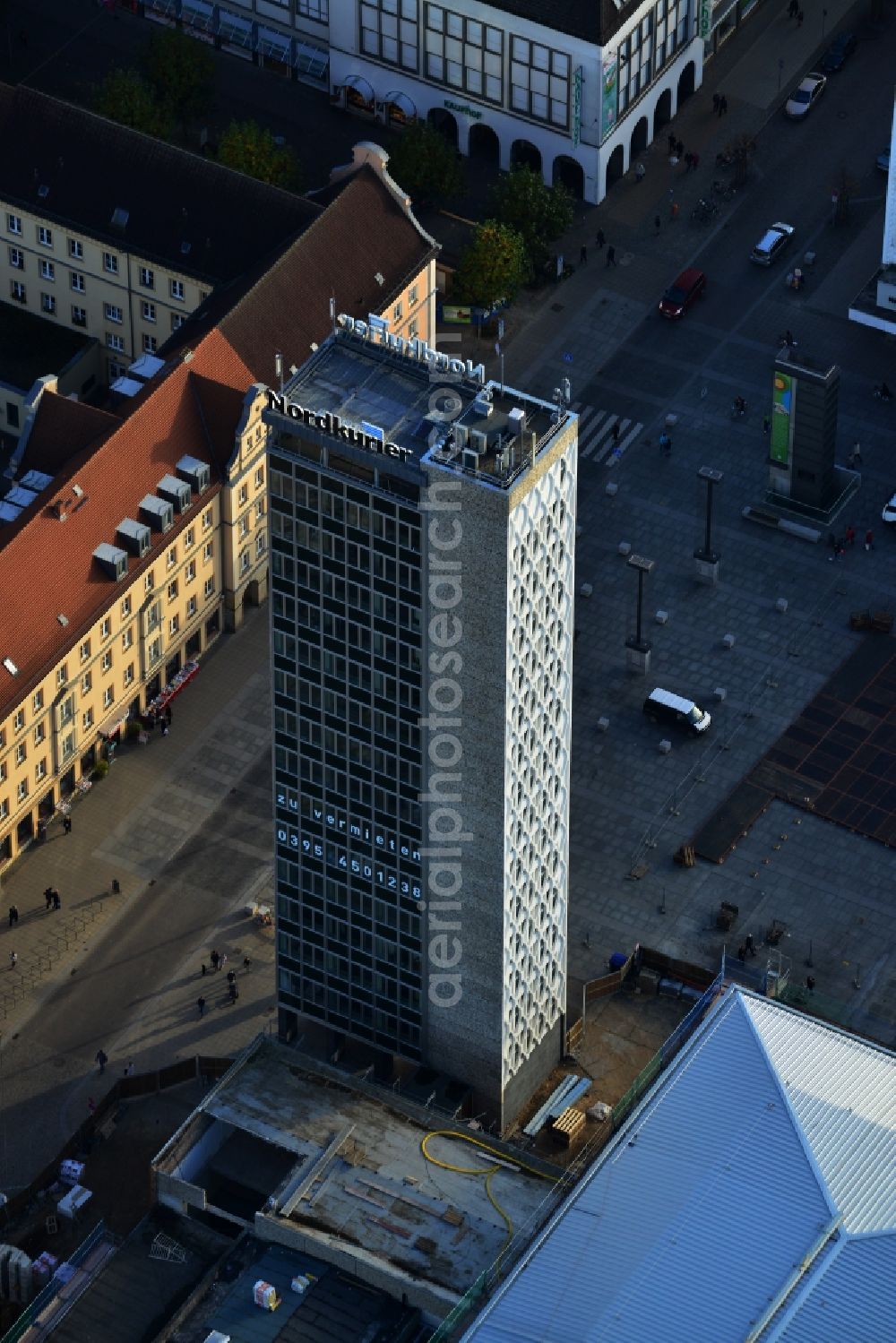 Aerial photograph Neubrandenburg - Office tower belonging to Haus der Kultur und Bildung HKB . The building is mainly used for commercial purposes. The WindBauer Gmbh and the RWI Regionale Wirtschaftsinitiative Ost Mecklenburg-Vorpommern e. V. have their headquarters here. The building is situated on Marktplatz in Neubrandenburg in Mecklenburg-Vorpommern