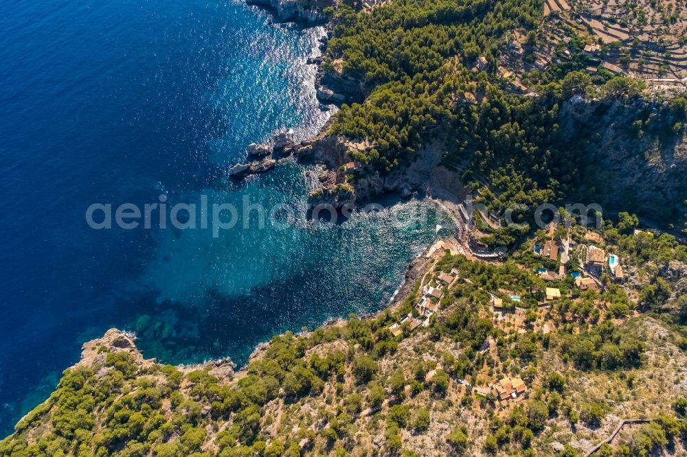 Aerial image Deia - Water surface at the bay along the sea coast Cale de Deya in Deia in Balearic island of Mallorca, Spain