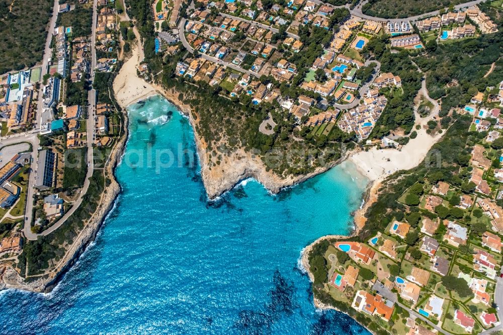 Cala Mendia from the bird's eye view: Water surface at the bay along the sea coast with the beaches Platja de Cala Anguila and Playa de Cala Mandia in Cala Mendia in Balearic island of Mallorca, Spain