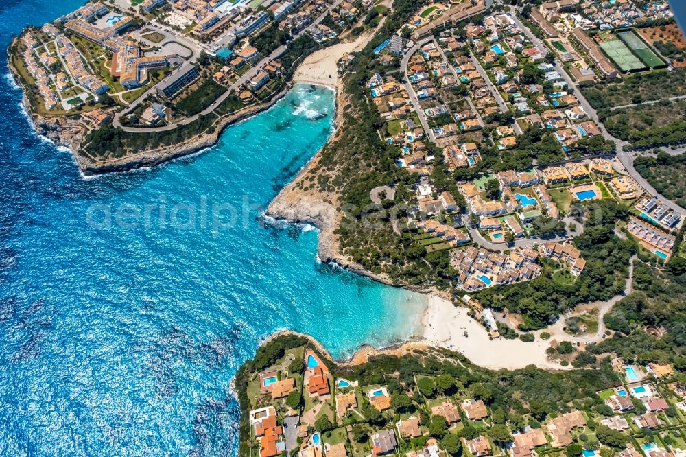 Aerial image Cala Mendia - Water surface at the bay along the sea coast with the beaches Platja de Cala Anguila and Playa de Cala Mandia in Cala Mendia in Balearic island of Mallorca, Spain