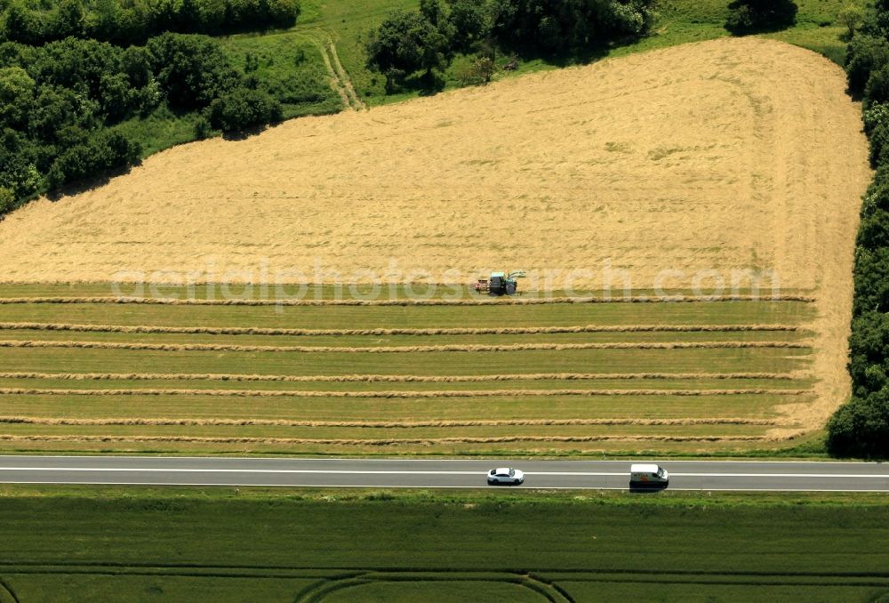 Aerial image Sondershausen - On the federal road B4 in Oberspier in Thuringia a pickup truck and a passenger car on the road. On the field, a tractor on the road, the bundles of straw