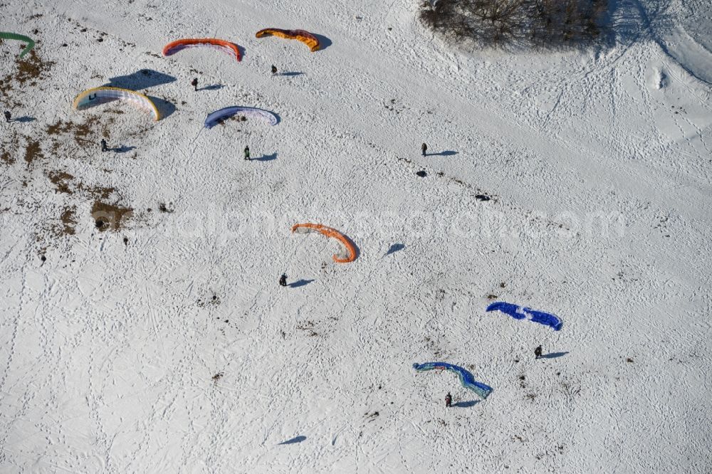 Aerial image Schmiedefeld am Rennsteig - Colorful Paraglider- flyer on a winter with Snowy hillside in Schmiedefeld in Thuringia