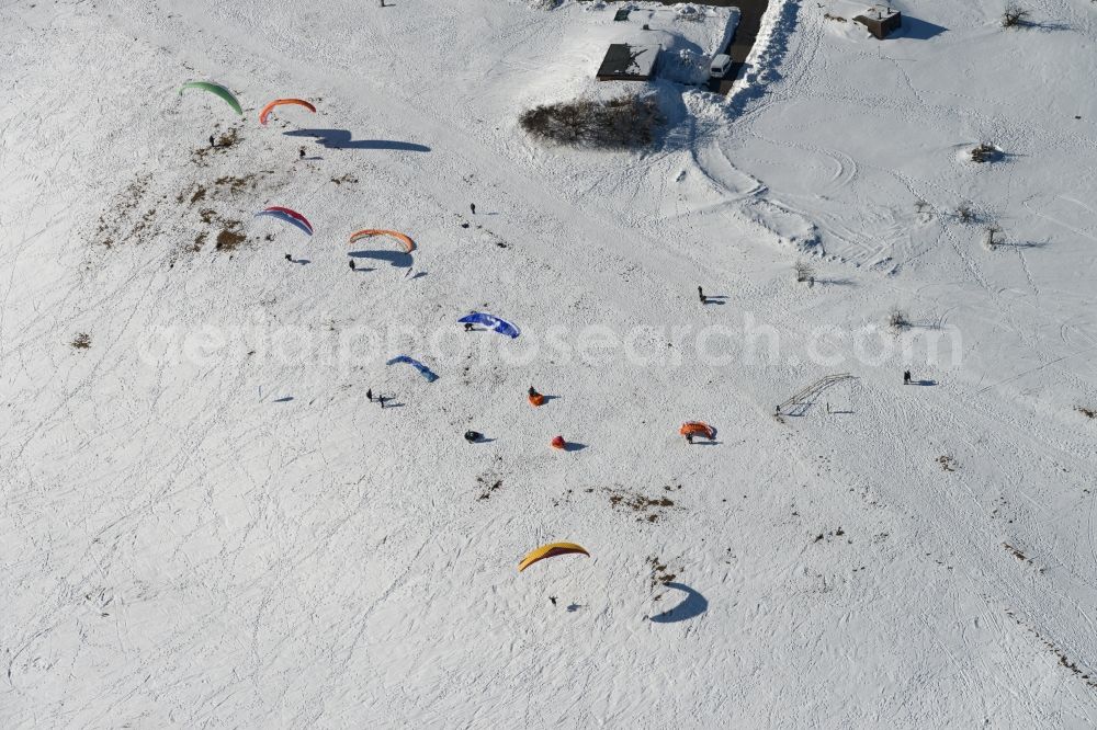 Schmiedefeld am Rennsteig from above - Colorful Paraglider- flyer on a winter with Snowy hillside in Schmiedefeld in Thuringia