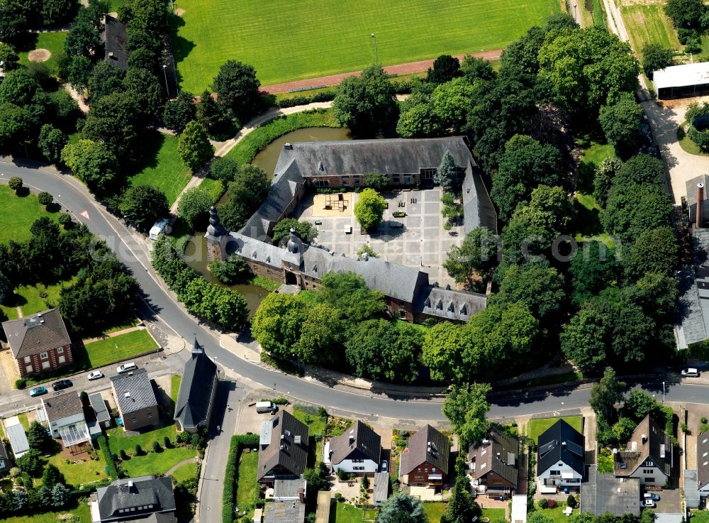 Birgel from the bird's eye view: Birgel Fortress in the Birgel part of the town of Düren in the state of North Rhine-Westphalia. The former water fortress with its distinct courtyard is surrounded by houses and residential homes and trees. It is located close to the church of St. Martinus. Today it is home to the public school Burg Birgel