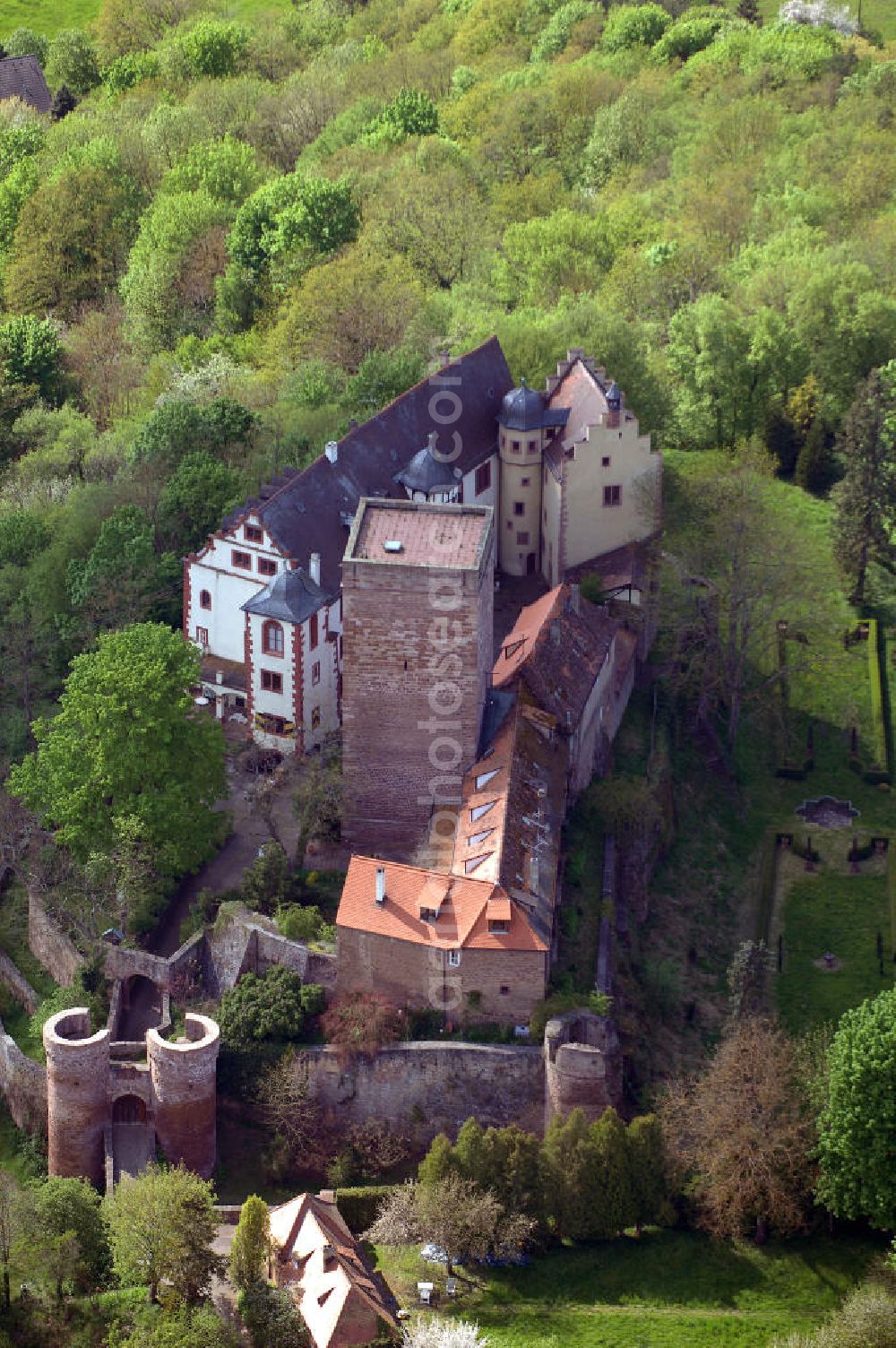 Aerial photograph GAMBURG - Die Burg Gamburg ist eine Burg bei Gamburg, einem Ortsteil der Gemeinde Werbach, im Main-Tauber-Kreis in Baden-Württemberg. Die Spornburg befindet sich direkt über Gamburg auf einem Bergsporn überhalb der Tauber.Die Burg ist im Privatbesitz und wird bewohnt. Die Burg wurde im 12. Jahrhundert von den Bischöfen von Mainz erbaut, erstmals 1157 als „castrum gamburc“ erwähnt und geht als Mainzer Lehen in den Besitz der Herren von Gamburg. Weitere Besitzer waren Eberhard Rüdt von Collenberg (1546) und Graf von Ingelheim (ab 1701). Seit 1982 ist die Burg im Besitz der Familie Mallinckrodt.Die Burganlage mit ovalem Grundriss besteht aus einem staufischen Bergfried mit einer Grundfläche von 10 x 10 Metern und einer Mauerstärke von 3 Metern, einer romanischen Bausubstanz, Palas mit spätromanischer Ausmalung, Wehrmauern, Tor mit zwei runden Ecktürmen, Halsgraben und einer ovalen Zwingeranlage. Früher befand sich im Palas eine Kapelle.