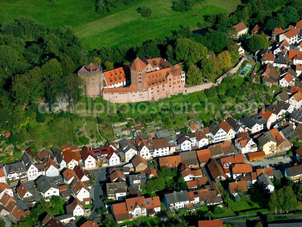 Rieneck from above - Fortress Rieneck above the town of Rieneck in the state of Bavaria. The fortress on the hill above the residential buildings of the historic town centre is mainly known for its elaborate castle keep and the redish facade. The castle keep is home to a tower chapel. Since 1959, it has been home to the Christian boy-scouts and has been used as a youth castle including sleeping facilities and event rooms