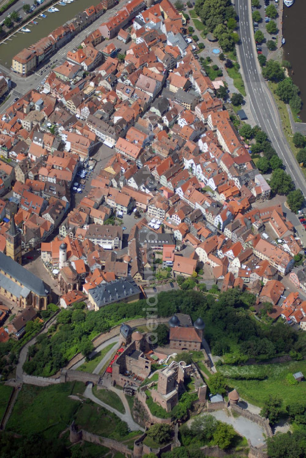 Wertheim from the bird's eye view: Blick auf Burg Wertheim bei Wertheim. Die Burg Wertheim ist eine Burg oberhalb der Stadt Wertheim. Sie ist eine der ältesten Burgruinen Baden-Württembergs. Die Grafen von Wertheim, Angehörige des fränkischen Adelsgeschlechts der Reginbodonen, nennen sich erstmals 1132 nach Wertheim. In diesem Jahrhundert wurde mit dem Bau der Burg begonnen. Bis ins 17. Jh. wurde der Grafensitz immer weiter mit wehrhaften Befestigungsanlagen und großen Wohnpalästen ausgebaut. Durch eine Pulverexplosion 1619 werden Teile der Burg zerstört.Im Dreißigjährigen Krieg wurde die Burg von den Schweden besetzt und durch den Beschuss der Kaiserlichen Truppen 1634 folgen weitere Zerstörungen. Seitdem liegt sie in Trümmern. Ab 1982 wird die Burgruine mit erheblicher Unterstützung des Landes Baden-Württemberg saniert. Seit 1995 ist sie im Besitz der Stadt Wertheim, die sie den Vorbesitzern, den ehemaligen Adelsgeschlechtern Löwenstein-Wertheim-Freudenberg und Löwenstein-Wertheim-Rosenberg, abkaufte. Sie Liegt direkt an der Grenze zu Bayern, so dass man auf beide Bundesländer Ausblick erhält. Im Hintergrund die Stadtansicht auf Wertheim, westlich von der Burg Wertheim.