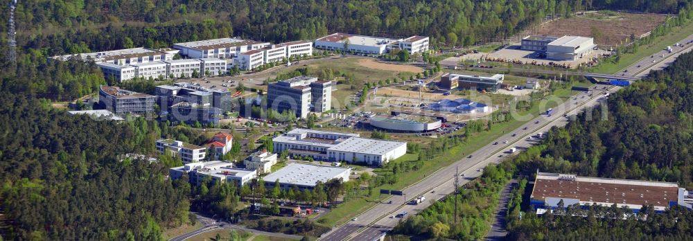 Kleinmachnow from the bird's eye view: Business Campus Europarc Dreilinden in Kleinmachnow in the state Brandenburg. The commercial area with its stores, shopping facilities and business building complexes is located on federal motorway A115 and is surrounded by forest