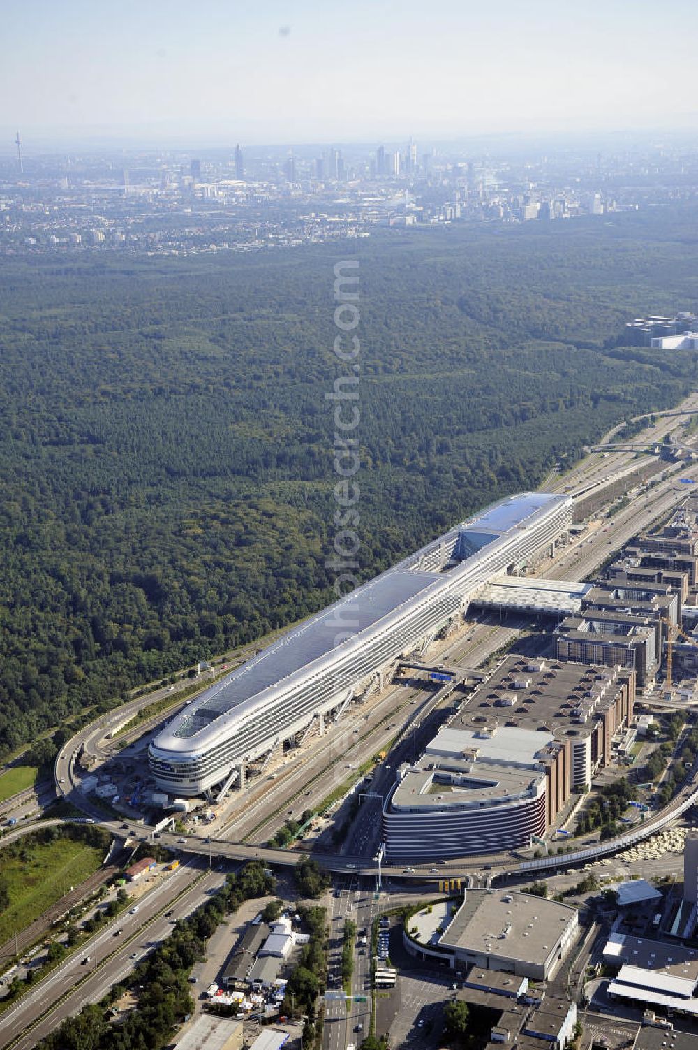 Frankfurt am Main from the bird's eye view: Blick auf das Businesscenter The Squaire, vormals als Airrail Center Frankfurt bekannt. Hauptinvestor für das futuristische Projekt ist die IVG Immobilien AG. Das 660 Meter lange und neun Etagen (45 Meter) hohe Gebäude wurde über dem Fernbahnhof gebaut, um eine zusätzliche Fläche für Büros, Hotels und Einkaufszentren zu bieten. Das u.a. mit der Streif Baulogistik GmbH errichtete Bauwerk ist auf die Decke des Fernbahnhofs gesetzt, die wie die Pfeiler des Grundbauwerks bereits entsprechend ausgelegt wurde. Das Center ist somit direkt mit dem Terminal 1 und dem Fernbahnhof verbunden. View of the Business Center The Squair, formerly known as Airrail Center Frankfurt. The main investor for the futuristic project is the IVG Immobilien AG.