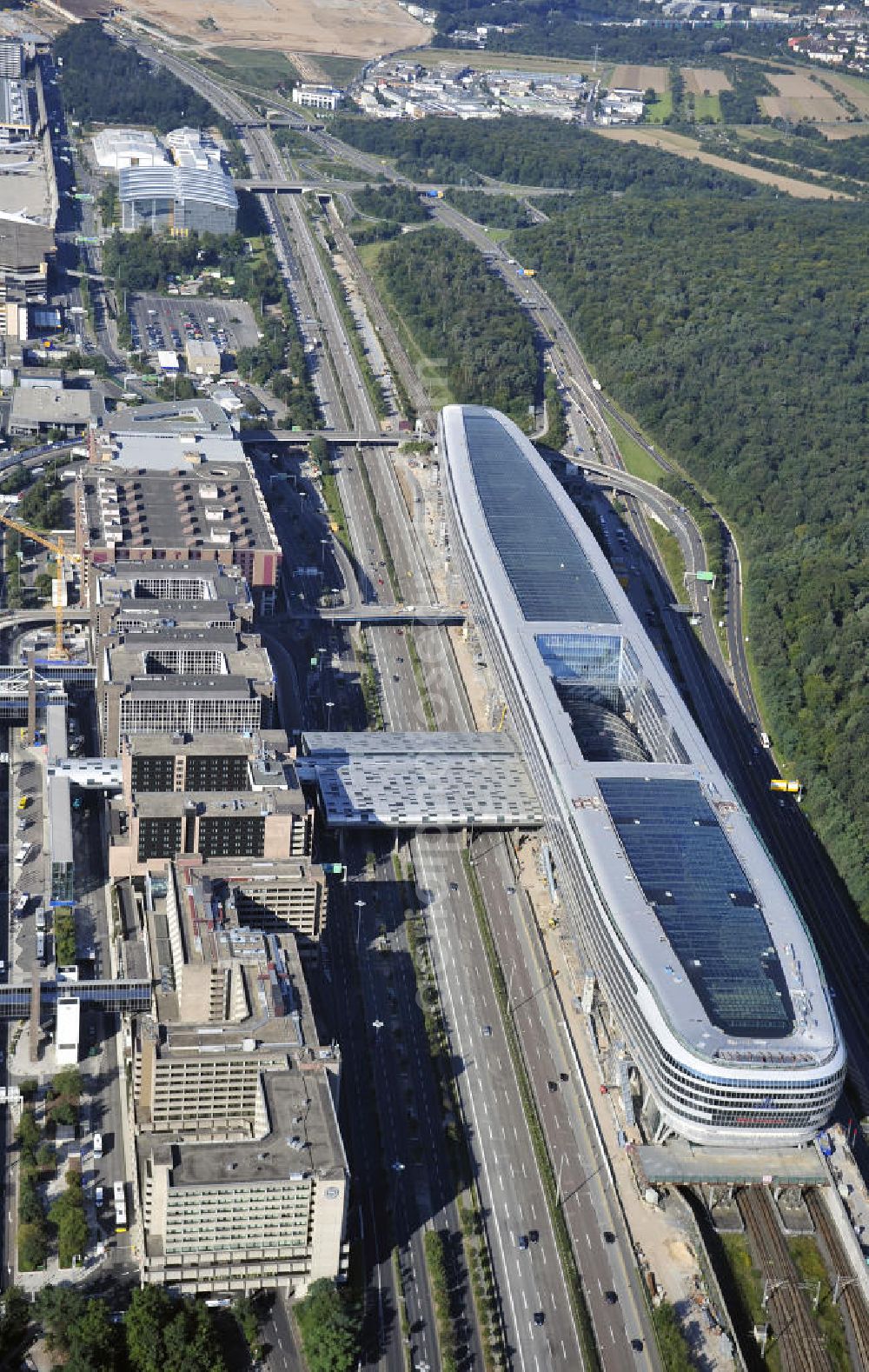 Aerial photograph Frankfurt am Main - Blick auf das Businesscenter The Squaire, vormals als Airrail Center Frankfurt bekannt. Hauptinvestor für das futuristische Projekt ist die IVG Immobilien AG. Das 660 Meter lange und neun Etagen (45 Meter) hohe Gebäude wurde über dem Fernbahnhof gebaut, um eine zusätzliche Fläche für Büros, Hotels und Einkaufszentren zu bieten. Das u.a. mit der Streif Baulogistik GmbH errichtete Bauwerk ist auf die Decke des Fernbahnhofs gesetzt, die wie die Pfeiler des Grundbauwerks bereits entsprechend ausgelegt wurde. Das Center ist somit direkt mit dem Terminal 1 und dem Fernbahnhof verbunden. View of the Business Center The Squair, formerly known as Airrail Center Frankfurt. The main investor for the futuristic project is the IVG Immobilien AG.