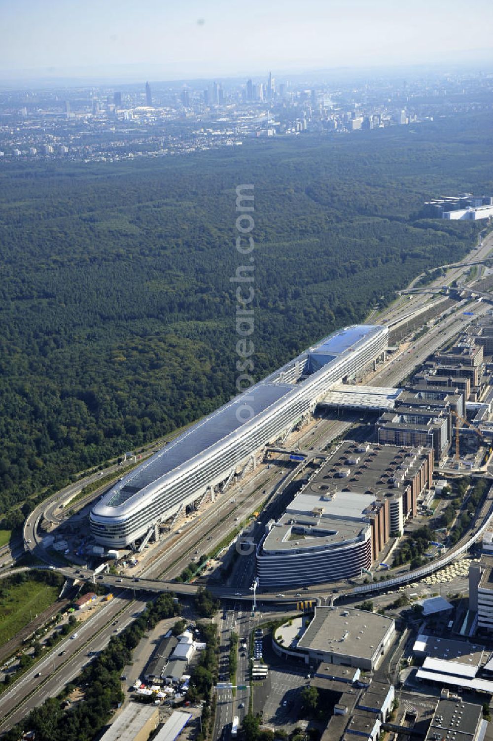 Frankfurt am Main from above - Blick auf das Businesscenter The Squaire, vormals als Airrail Center Frankfurt bekannt. Hauptinvestor für das futuristische Projekt ist die IVG Immobilien AG. Das 660 Meter lange und neun Etagen (45 Meter) hohe Gebäude wurde über dem Fernbahnhof gebaut, um eine zusätzliche Fläche für Büros, Hotels und Einkaufszentren zu bieten. Das u.a. mit der Streif Baulogistik GmbH errichtete Bauwerk ist auf die Decke des Fernbahnhofs gesetzt, die wie die Pfeiler des Grundbauwerks bereits entsprechend ausgelegt wurde. Das Center ist somit direkt mit dem Terminal 1 und dem Fernbahnhof verbunden. View of the Business Center The Squair, formerly known as Airrail Center Frankfurt. The main investor for the futuristic project is the IVG Immobilien AG.