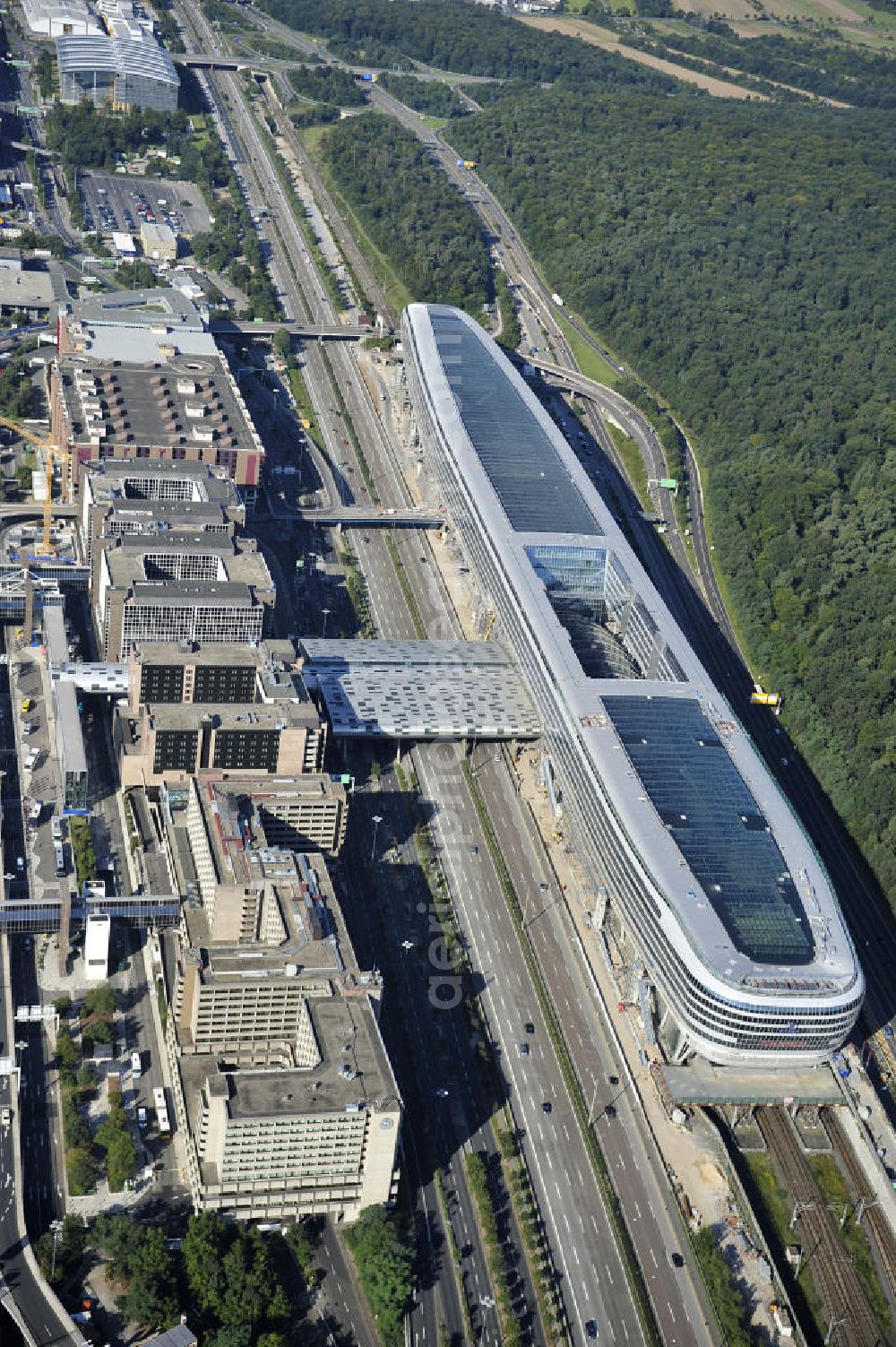 Frankfurt am Main from above - Blick auf das Businesscenter The Squaire, vormals als Airrail Center Frankfurt bekannt. Hauptinvestor für das futuristische Projekt ist die IVG Immobilien AG. Das 660 Meter lange und neun Etagen (45 Meter) hohe Gebäude wurde über dem Fernbahnhof gebaut, um eine zusätzliche Fläche für Büros, Hotels und Einkaufszentren zu bieten. Das u.a. mit der Streif Baulogistik GmbH errichtete Bauwerk ist auf die Decke des Fernbahnhofs gesetzt, die wie die Pfeiler des Grundbauwerks bereits entsprechend ausgelegt wurde. Das Center ist somit direkt mit dem Terminal 1 und dem Fernbahnhof verbunden. View of the Business Center The Squair, formerly known as Airrail Center Frankfurt. The main investor for the futuristic project is the IVG Immobilien AG.