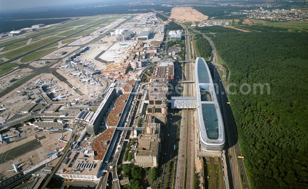 Aerial photograph Frankfurt am Main - Blick auf das Businesscenter The Squaire, vormals als Airrail Center Frankfurt bekannt. Hauptinvestor für das futuristische Projekt ist die IVG Immobilien AG. Das 660 Meter lange und neun Etagen (45 Meter) hohe Gebäude wurde über dem Fernbahnhof gebaut, um eine zusätzliche Fläche für Büros, Hotels und Einkaufszentren zu bieten. Das u.a. mit der Streif Baulogistik GmbH errichtete Bauwerk ist auf die Decke des Fernbahnhofs gesetzt, die wie die Pfeiler des Grundbauwerks bereits entsprechend ausgelegt wurde. Das Center ist somit direkt mit dem Terminal 1 und dem Fernbahnhof verbunden. View of the Business Center The Squair, formerly known as Airrail Center Frankfurt. The main investor for the futuristic project is the IVG Immobilien AG.