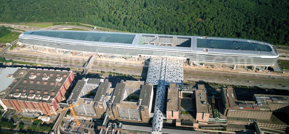 Aerial photograph Frankfurt am Main - Blick auf das Businesscenter The Squaire, vormals als Airrail Center Frankfurt bekannt. Hauptinvestor für das futuristische Projekt ist die IVG Immobilien AG. Das 660 Meter lange und neun Etagen (45 Meter) hohe Gebäude wurde über dem Fernbahnhof gebaut, um eine zusätzliche Fläche für Büros, Hotels und Einkaufszentren zu bieten. Das u.a. mit der Streif Baulogistik GmbH errichtete Bauwerk ist auf die Decke des Fernbahnhofs gesetzt, die wie die Pfeiler des Grundbauwerks bereits entsprechend ausgelegt wurde. Das Center ist somit direkt mit dem Terminal 1 und dem Fernbahnhof verbunden. View of the Business Center The Squair, formerly known as Airrail Center Frankfurt. The main investor for the futuristic project is the IVG Immobilien AG.