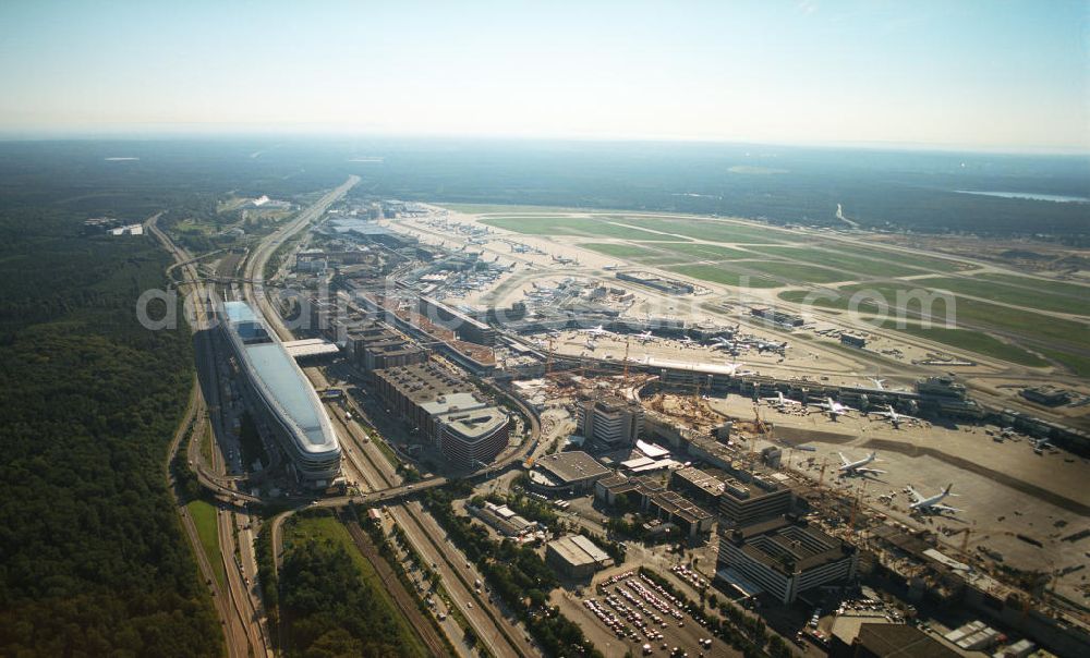 Frankfurt am Main from the bird's eye view: Blick auf das Businesscenter The Squaire, vormals als Airrail Center Frankfurt bekannt. Hauptinvestor für das futuristische Projekt ist die IVG Immobilien AG. Das 660 Meter lange und neun Etagen (45 Meter) hohe Gebäude wurde über dem Fernbahnhof gebaut, um eine zusätzliche Fläche für Büros, Hotels und Einkaufszentren zu bieten. Das u.a. mit der Streif Baulogistik GmbH errichtete Bauwerk ist auf die Decke des Fernbahnhofs gesetzt, die wie die Pfeiler des Grundbauwerks bereits entsprechend ausgelegt wurde. Das Center ist somit direkt mit dem Terminal 1 und dem Fernbahnhof verbunden. View of the Business Center The Squair, formerly known as Airrail Center Frankfurt. The main investor for the futuristic project is the IVG Immobilien AG.