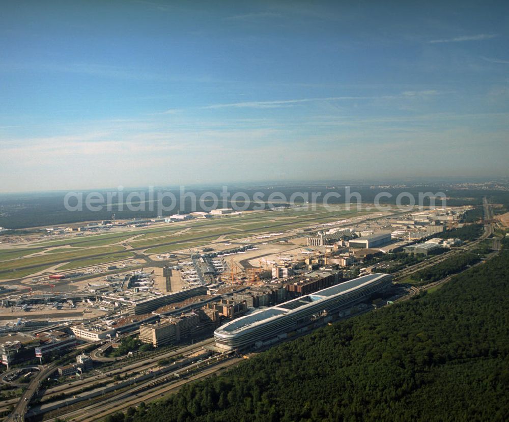 Aerial photograph Frankfurt am Main - Blick auf das Businesscenter The Squaire, vormals als Airrail Center Frankfurt bekannt. Hauptinvestor für das futuristische Projekt ist die IVG Immobilien AG. Das 660 Meter lange und neun Etagen (45 Meter) hohe Gebäude wurde über dem Fernbahnhof gebaut, um eine zusätzliche Fläche für Büros, Hotels und Einkaufszentren zu bieten. Das u.a. mit der Streif Baulogistik GmbH errichtete Bauwerk ist auf die Decke des Fernbahnhofs gesetzt, die wie die Pfeiler des Grundbauwerks bereits entsprechend ausgelegt wurde. Das Center ist somit direkt mit dem Terminal 1 und dem Fernbahnhof verbunden. View of the Business Center The Squair, formerly known as Airrail Center Frankfurt. The main investor for the futuristic project is the IVG Immobilien AG.