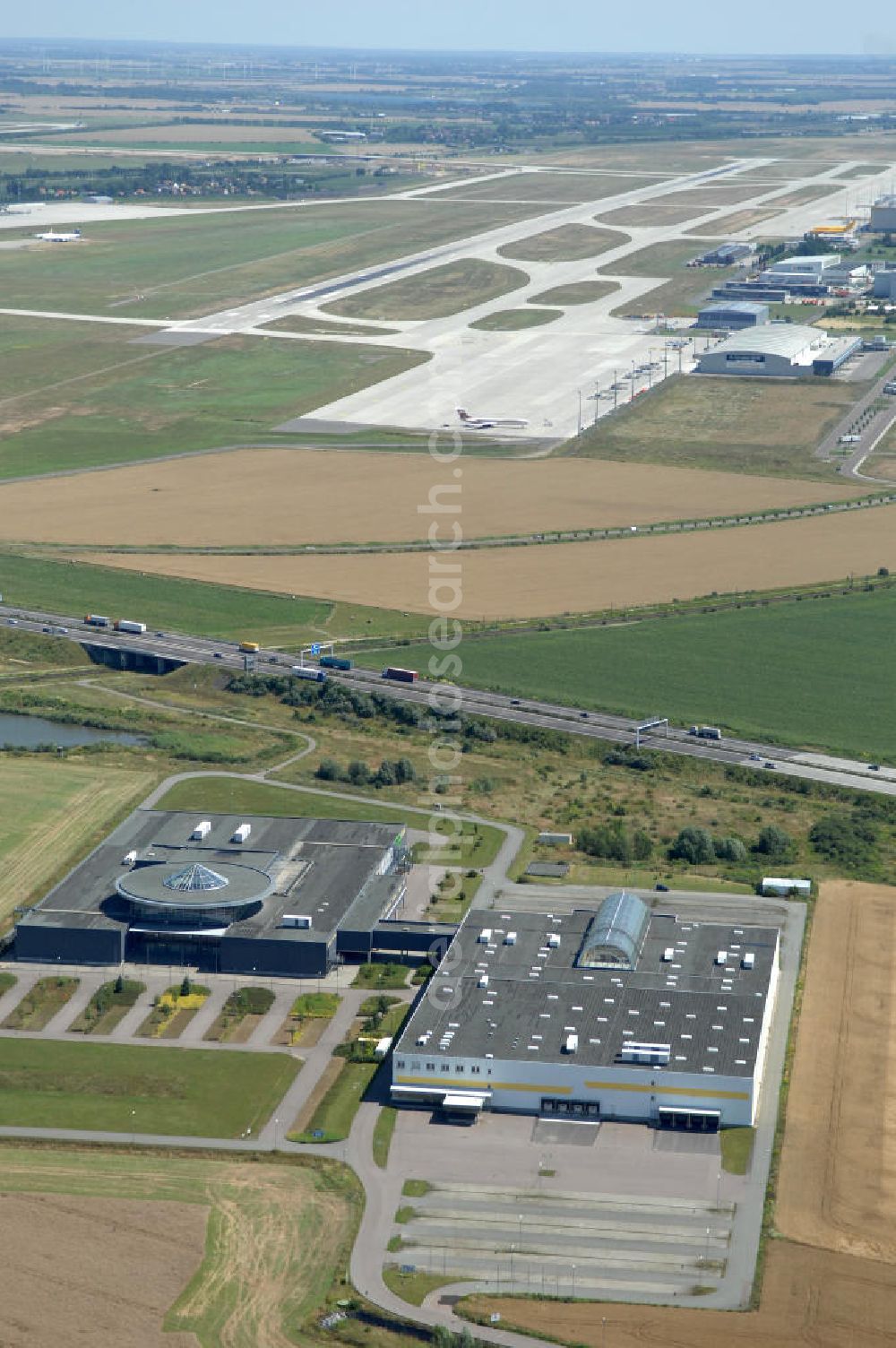 Schkeuditz from the bird's eye view: Blick auf den Businesspark an der A9 in Schkeuditz bei Leipzig im Bundesland Sachsen. Das Areal in unmittelbarer Nähe zum Flughafen Leipzig-Halle wurde für Unternehmen des produzierenden Gewerbe, der Logistik, für Büro und Verwaltung entwickelt. Die zwei Hauptgebäude wurden bis 2005 als Möbelhaus betrieben und werden von Bierwagen Immobilien vermietet.