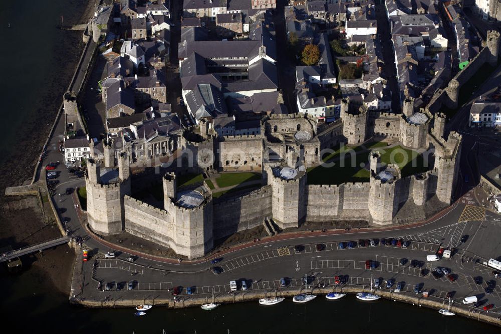 Aerial image Caernarfon - Blick auf das Schloss Caernarfon Castle in Caernarfon in Nordwest-Wales. Die gewaltige Burganlage gehört zu eine der bekanntesten historischen Festungen Großbritanniens. 1911 fand im Innenhof erstmals die zeremonielle Verleihung des Titels Prince of Wales an den englischen Thronfolger statt. View of the Caernarfon Castle in north Wales. The massive castle is one of the most famous historical forts in Britain. In 1911, Caernarfon was used for the investiture of the Prince of Wales for the first time.