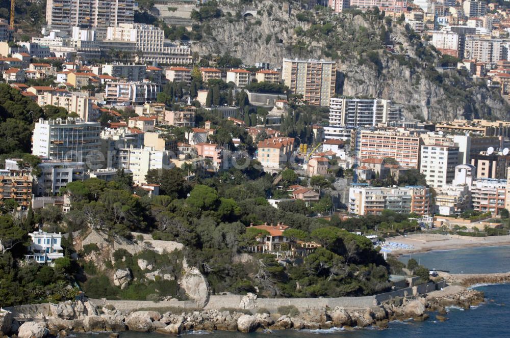 Cap-d' Ail from the bird's eye view: Blick auf ein Wohngebiet entlang der Avenue des Douaniers in Cap-d' Ail und auf den Stadtteil Fontvieille von Monaco. Cap-d' Ail ist ein kleiner französischer Badeort an der Cote d' Azur und Grenzort zum Fürstentum Monaco. Die deutsche Übersetzung des Namens lautet „Knoblauchkap“. Der Ort liegt am Fuße des steil aufragenden Bergs Tete de Chien bei La Turbie.Fontvieille ist ein Stadtbezirk (frz. quartier) im Fürstentum Monaco an der Cote d' Azur. Er stellt den südlichsten Teil des Stadtstaates dar, der auf einer Fläche von 32,4 ha etwa 3300 Einwohner (dies entspricht einem Zehntel der Bevölkerung des Landes) hat.