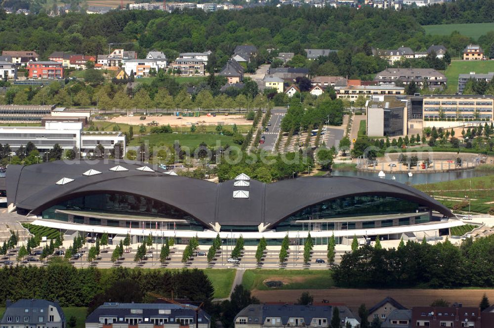 Aerial photograph Luxemburg - Blick auf das Centre National Sportif et Culturel dCoque an der Rue Leon Hengen / Avenue John Fitzgerald Kennedy. Das dCoque ist das größte Sportzentrum des Großherzogtums Luxemburg. Es liegt auf dem Kirchberg-Plateau. Die Coque trägt ihren Namen aufgrund der Form ihrer Hallenkonstruktion, die an eine Jakobsmuschel erinnert. Das Zentrum wurde Ende der 1990er Jahre als Erweiterung der Piscine Olympique Luxembourg erbaut. Neben seiner Funktion als Sportzentrum wird es für Großveranstaltungen, Konzerte und als Konferenzzentrum verwendet. Die Arena umfasst 8000 Plätze und 4300 Quadratmeter. Der Architekt ist Roger Taillibert. Kontakt: Tel. +352 436060222,