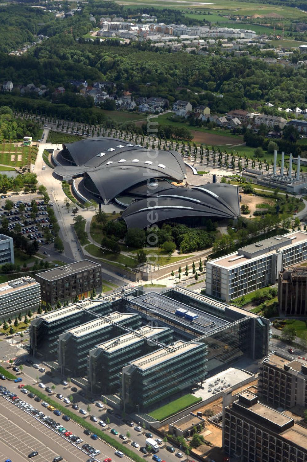 Aerial image Luxemburg - Blick auf das Centre National Sportif et Culturel dCoque an der Rue Leon Hengen / Avenue John Fitzgerald Kennedy. Das dCoque ist das größte Sportzentrum des Großherzogtums Luxemburg. Es liegt auf dem Kirchberg-Plateau. Die Coque trägt ihren Namen aufgrund der Form ihrer Hallenkonstruktion, die an eine Jakobsmuschel erinnert. Das Zentrum wurde Ende der 1990er Jahre als Erweiterung der Piscine Olympique Luxembourg erbaut. Neben seiner Funktion als Sportzentrum wird es für Großveranstaltungen, Konzerte und als Konferenzzentrum verwendet. Die Arena umfasst 8000 Plätze und 4300 Quadratmeter. Der Architekt ist Roger Taillibert. Kontakt: Tel. +352 436060222,