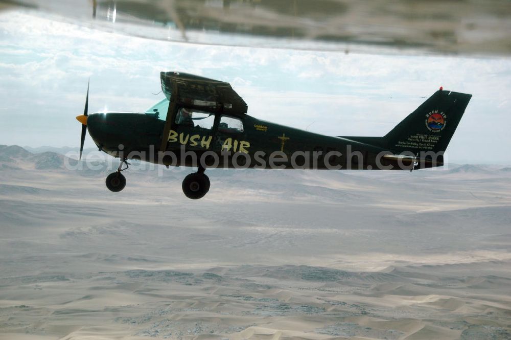 Windhoeck from above - Eine als Buschflieger genutzte Cessna 182 im Formationsflug über der Wüste in Namibia. A Cessna 182 flying low in the surrounding areas of Sandfontein.