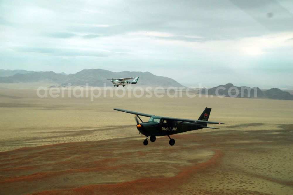 Aerial image Windhoeck - Eine als Buschflieger genutzte Cessna 182 im Formationsflug über der Wüste in Namibia. A Cessna 182 flying low in the surrounding areas of Sandfontein.