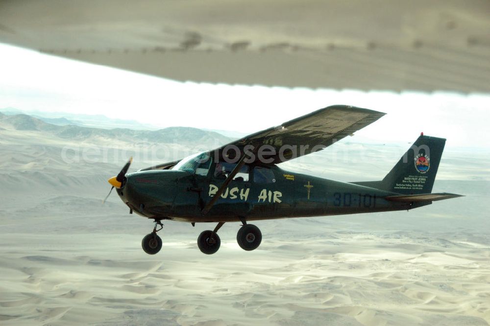 Windhoeck from above - Eine als Buschflieger genutzte Cessna 182 im Formationsflug über der Wüste in Namibia. A Cessna 182 flying low in the surrounding areas of Sandfontein.