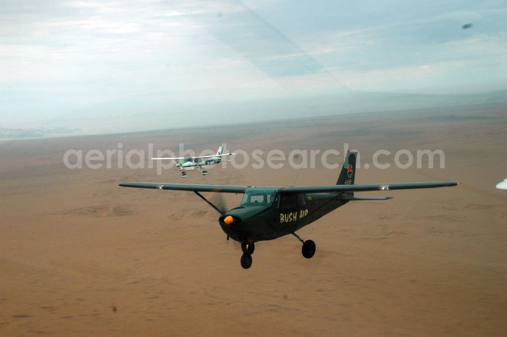 Aerial image Windhoeck - Eine als Buschflieger genutzte Cessna 182 im Formationsflug über der Wüste in Namibia. A Cessna 182 flying low in the surrounding areas of Sandfontein.