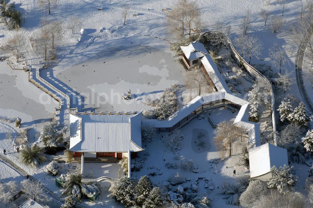 Aerial image Berlin - Blick auf den mit Schnee bedecktem nördlichen Teil des Chinesischen Garten in den Gärten der Welt im Erholungspark Marzahn. Dieser Teil beinhaltet die Eingangshalle „Stube des heiteren Wetters“, die Kleine Halle „Pavillon des ruhigen Mondscheins“ und das Teehaus „Berghaus zum Osmanthussaft“, mit Zick-Zack Brücke. Der kleine See ist zugefroren / mit Eis bedeckt. Kontakt: Grün Berlin Park und Garten GmbH, Sangerhauser Weg 1, 12349 Berlin, Tel. +49(0)30 700906 0, Fax +49(0)30 700906 70, E-Mail: info@gruen-berlin.de