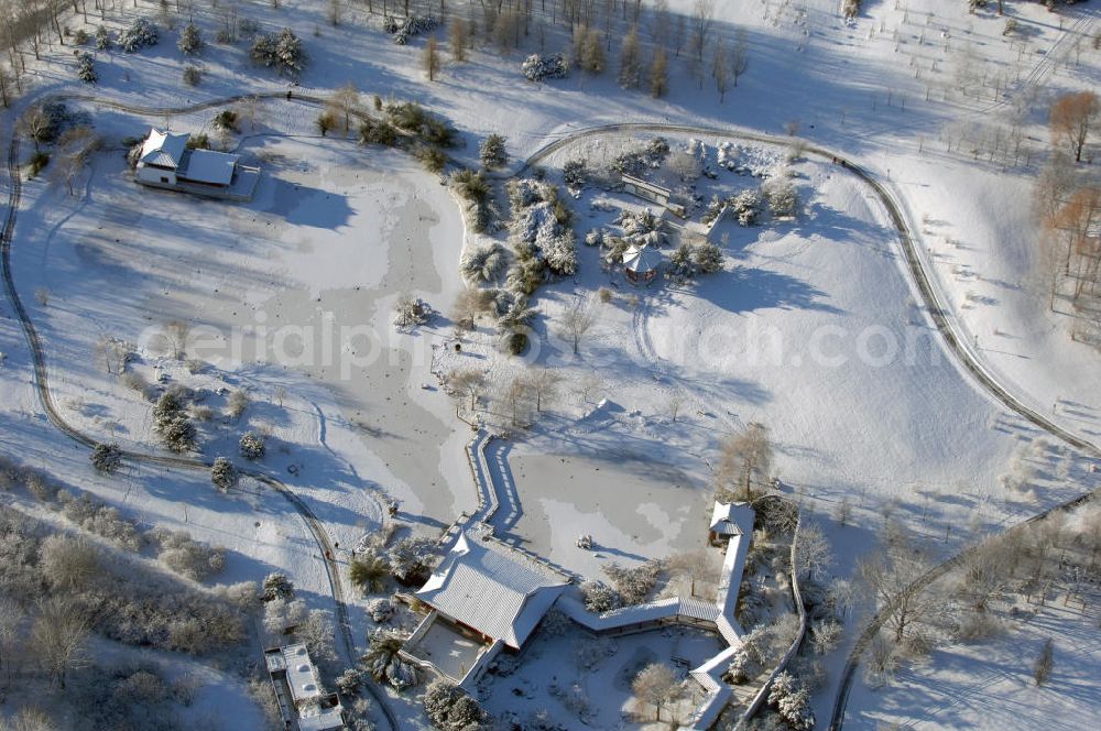 Berlin from above - Blick auf den mit Schnee bedecktem Chinesischen Garten in den Gärten der Welt im Erholungspark Marzahn. Hier die Kleine Halle „Pavillon des ruhigen Mondscheins“, das Teehaus „Berghaus zum Osmanthussaft“, mit Zick-Zack Brücke, den Oktagonal-Pavillion und dem Steinboot „Blick auf den Mond“. Der kleine See ist zugefroren / mit Eis bedeckt. Kontakt: Grün Berlin Park und Garten GmbH, Sangerhauser Weg 1, 12349 Berlin, Tel. +49(0)30 700906 0, Fax +49(0)30 700906 70, E-Mail: info@gruen-berlin.de