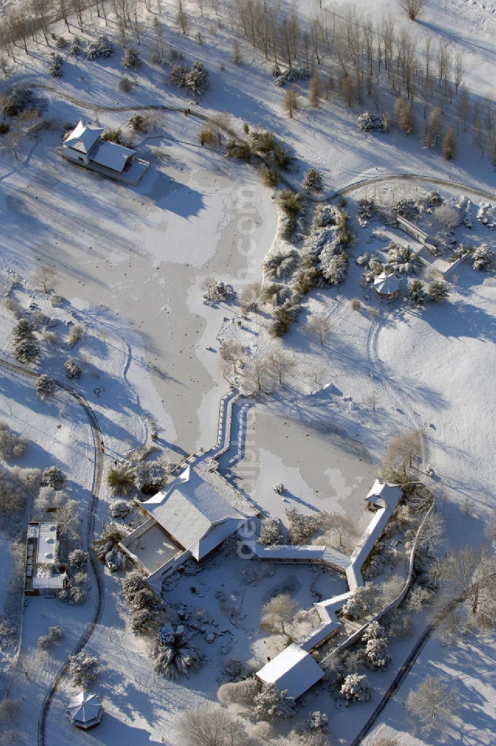 Berlin from the bird's eye view: Blick auf den mit Schnee bedecktem Chinesischen Garten in den Gärten der Welt im Erholungspark Marzahn. Dieser Teil beinhaltet die Eingangshalle „Stube des heiteren Wetters“, die Kleine Halle „Pavillon des ruhigen Mondscheins“, das Teehaus „Berghaus zum Osmanthussaft“, mit Zick-Zack Brücke, den Tsingtao-Pavillon, den Oktagonal-Pavillion und dem Steinboot „Blick auf den Mond“. Der kleine See ist zugefroren / mit Eis bedeckt. Kontakt: Grün Berlin Park und Garten GmbH, Sangerhauser Weg 1, 12349 Berlin, Tel. +49(0)30 700906 0, Fax +49(0)30 700906 70, E-Mail: info@gruen-berlin.de