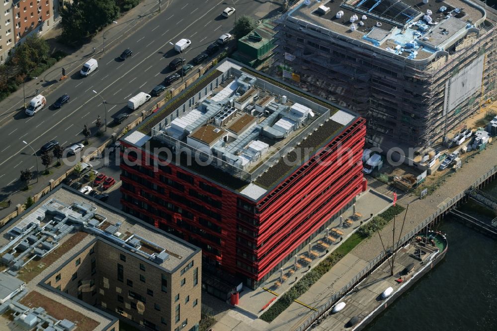 Aerial photograph Berlin - Coca-Cola- House on Stralauer Allee and the riverbank of the Spree in the Friedrichshain part of Berlin in Germany. The red building is part of a series of new buildings on the river