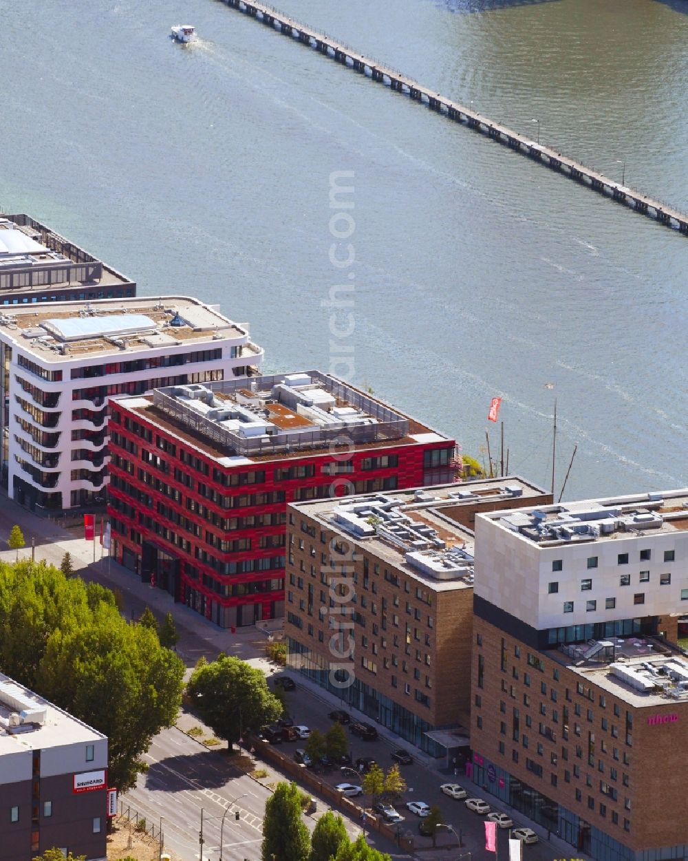 Berlin from the bird's eye view: Coca-Cola- House on Stralauer Allee and the riverbank of the Spree in the Friedrichshain part of Berlin in Germany. The red building is part of a series of new buildings on the river