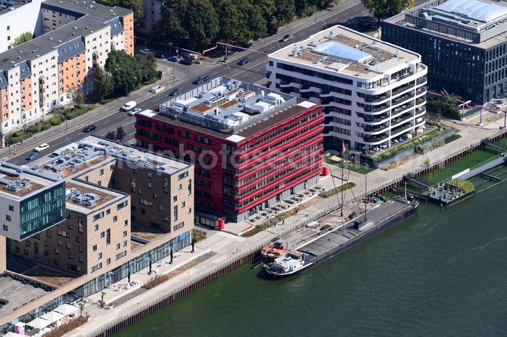 Aerial photograph Berlin - Coca-Cola- House on Stralauer Allee and the riverbank of the Spree in the Friedrichshain part of Berlin in Germany. The red building is part of a series of new buildings on the river